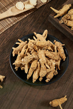 Dried roots in a dark bowl on a wooden board