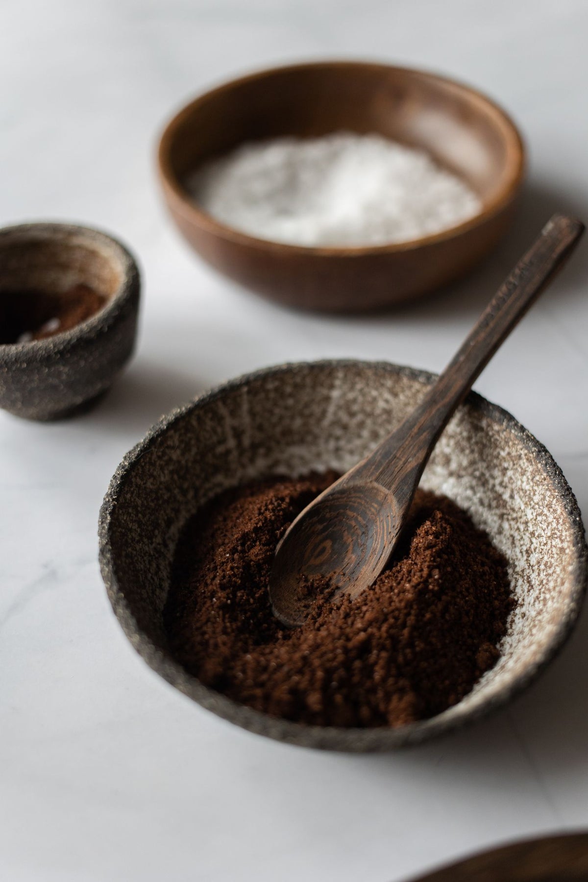 Ashwagandha root powder in a stoneware bowl with a wooden spoon
