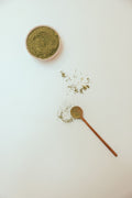 Green powder with a wooden spoon
