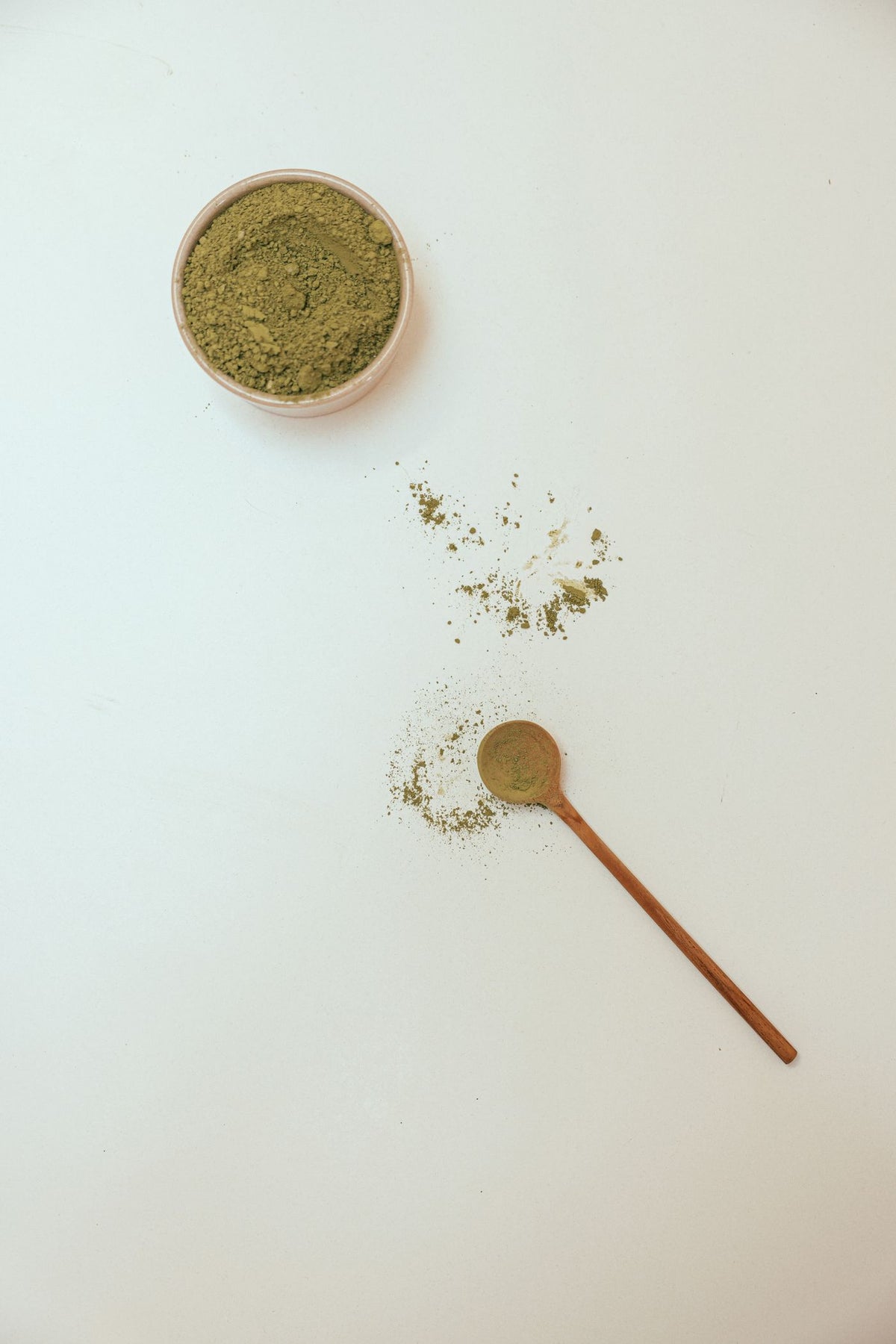 Green powder with a wooden spoon